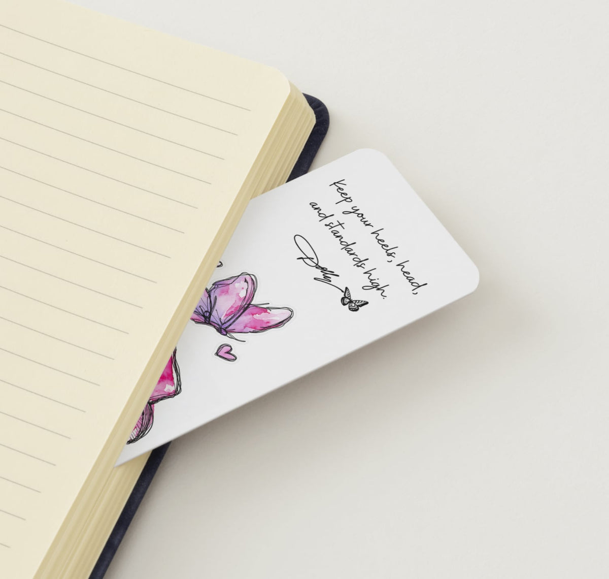 Dolly Day 🦋🩷 | Limited Edition Watercolor Bookmark. A white pocket notebook bookmark with a pink butterfly illustration and the quote 'Keep your head, and your standards high.' by J.