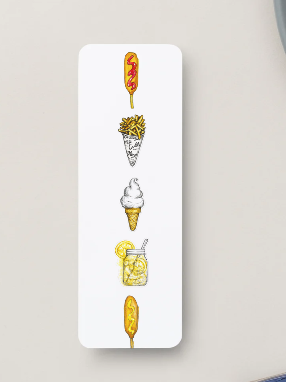 A white rectangular bookmark with rounded corners, featuring a vertical row of hand-drawn food illustrations including a corn dog with ketchup, fries, ice cream cone, lemon shake up, and another corn dog with mustard on a light beige background.