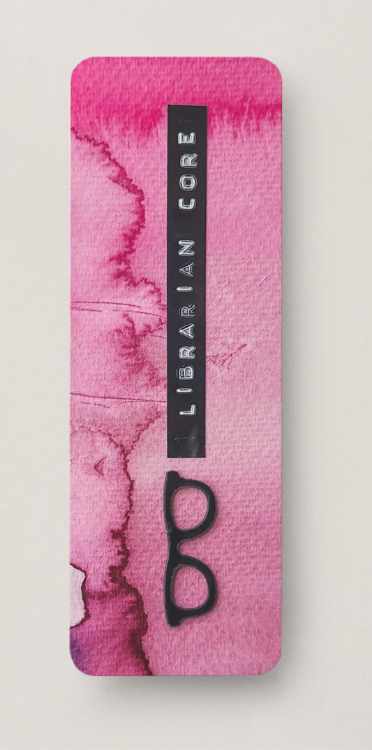 Pink watercolor design with black glasses and 'Librarian Core' text on a white background